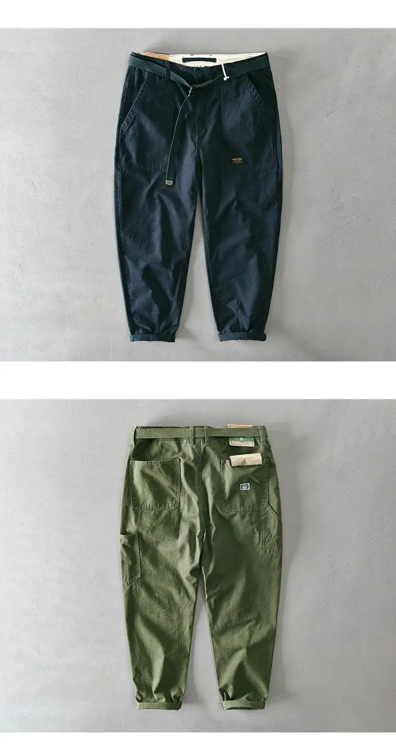 Two pairs of men's cargo pants in navy and olive green cotton, belted jogger-style with pockets.