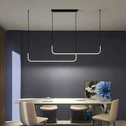 Modern LED strip chandelier, three gold curved U-shaped pendant lights over a dining table