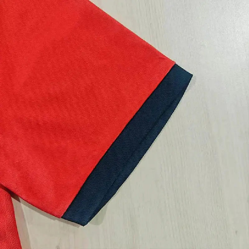 Men's red rugby polo shirt with navy cuff, short sleeve.