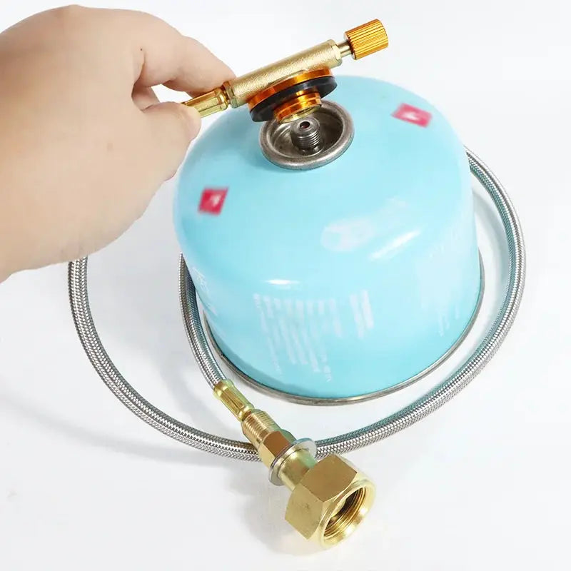 Camping gas refill adapter connected to blue cylinder with braided hose and brass fittings
