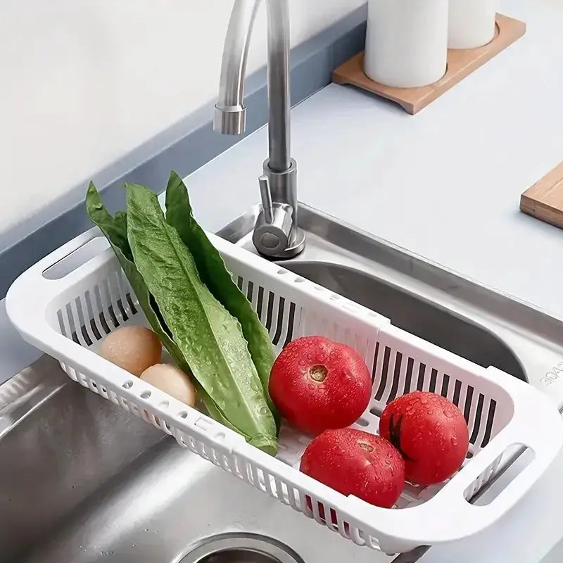 Kitchen storage rack, white plastic adjustable sink basket holding lettuce and three tomatoes