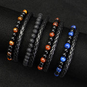 Five unisex beaded bracelets with black braided bands and tiger eye, lava stone, red jasper, and blue lapis beads