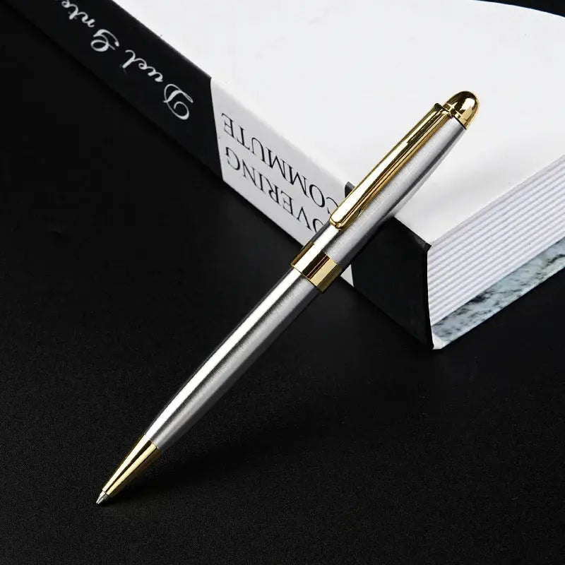 Ballpoint pen with silver barrel and gold-tone trim, Simples Market signature pen.