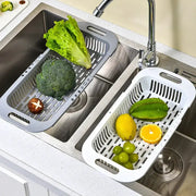 Simples Market kitchen storage rack with dual white and gray drain baskets holding lettuce, broccoli, lemon and grapes.