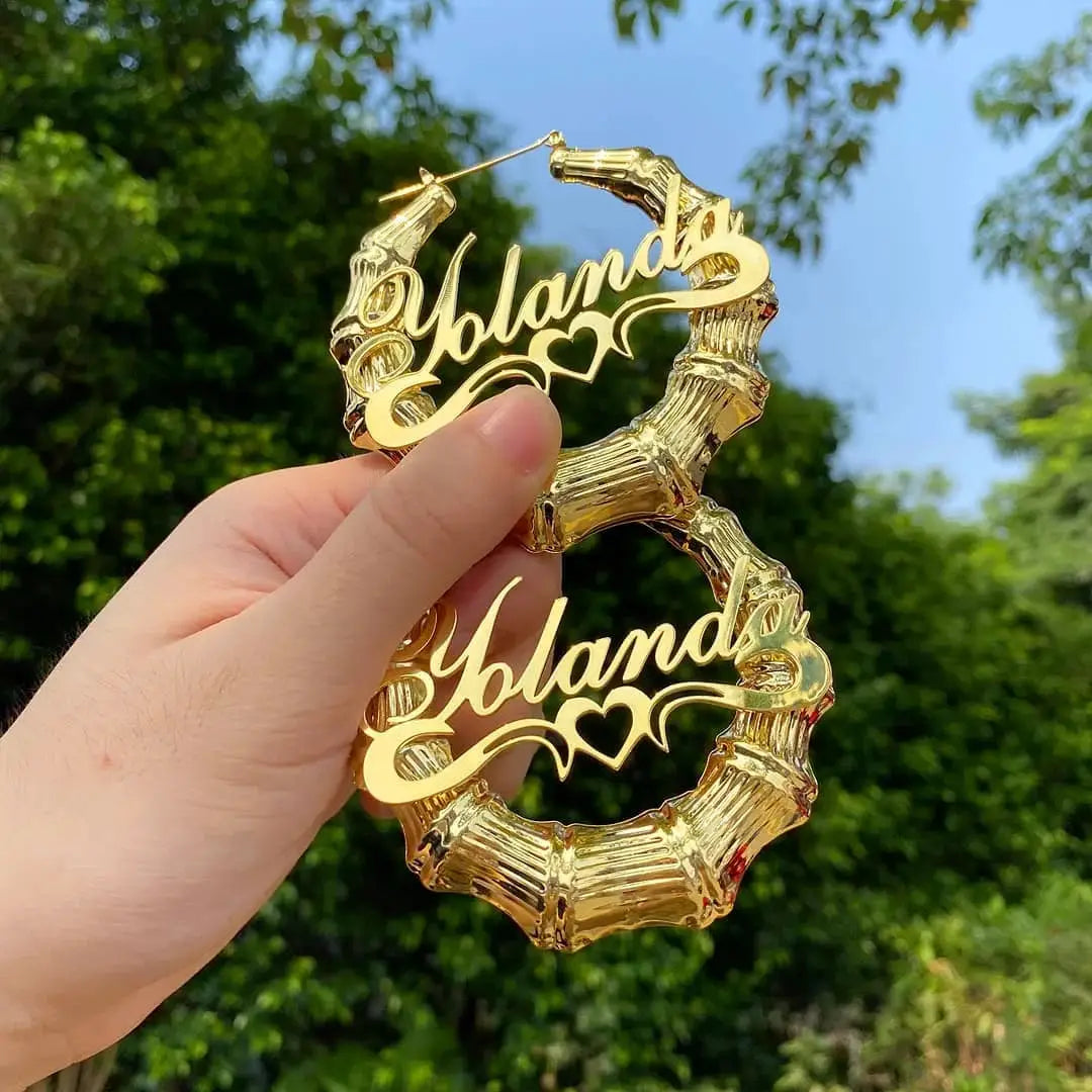 Two gold-tone bamboo hoop earrings with Holland name pendants
