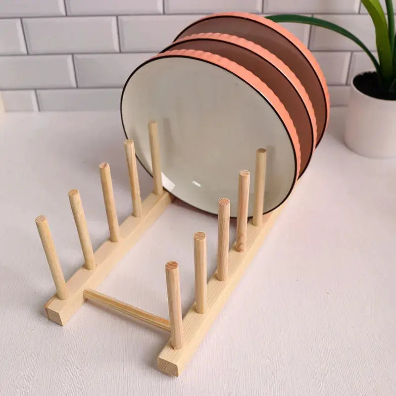 Wooden dish drying rack with pegs and brown round coasters