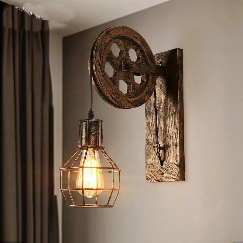 Vintage industrial wall lamp with a wooden pulley wheel and wire cage bulb, dark bronze finish
