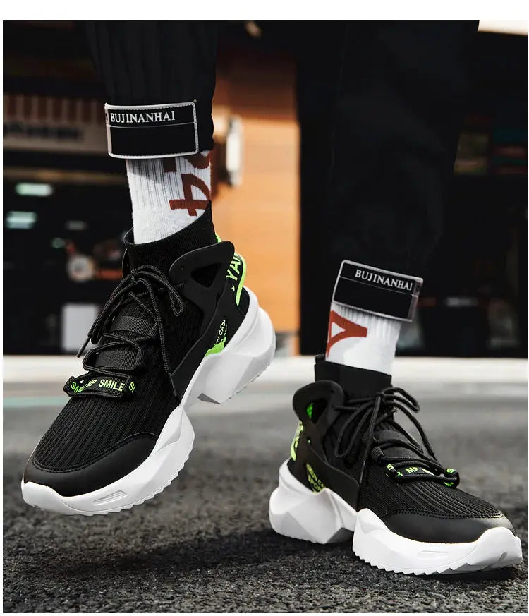Pair of men's black breathable sneakers with white chunky sole and neon green accents; BUJINANHAI branding visible