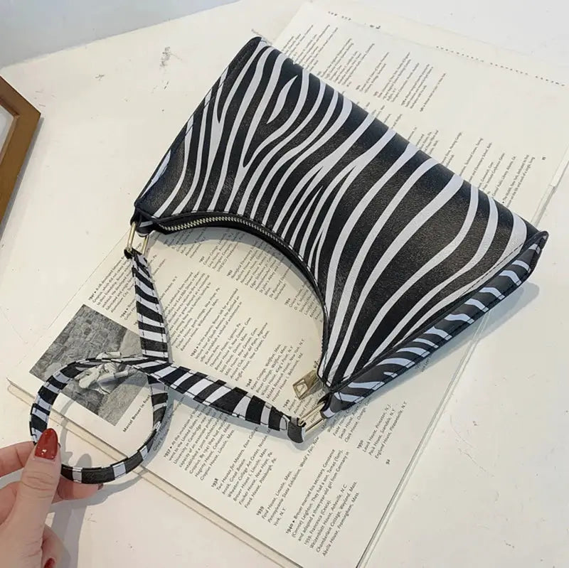 Zebra‑print PU leather shoulder bag with gold zipper and circular striped strap