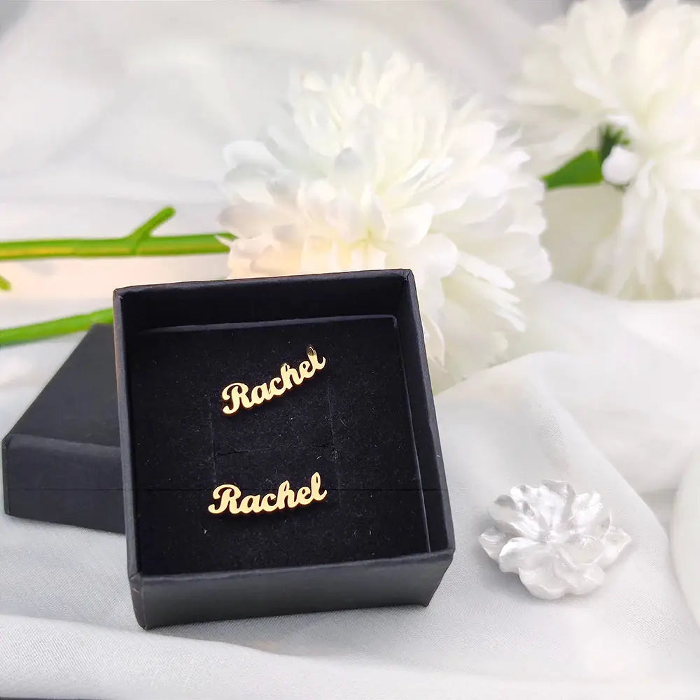 Gold-tone stainless steel custom name earrings, personalized Rachel name studs, two-piece set in a black jewelry box.