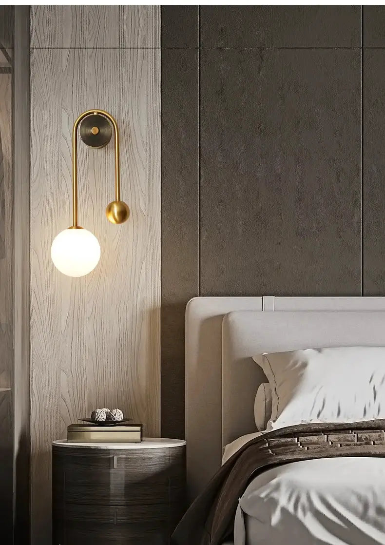 Modern wall lamp with glass globe shade in a gold finish, LED lighting Nordic bedside sconce.