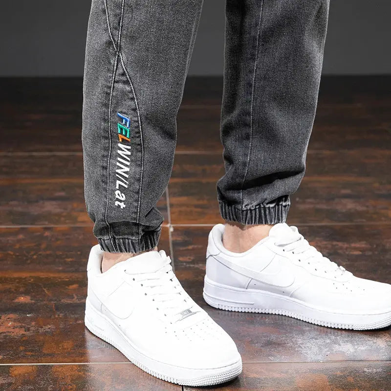 Men's cargo denim jogger jeans in black/gray with elastic cuffs; Simples Market logo visible on leg.