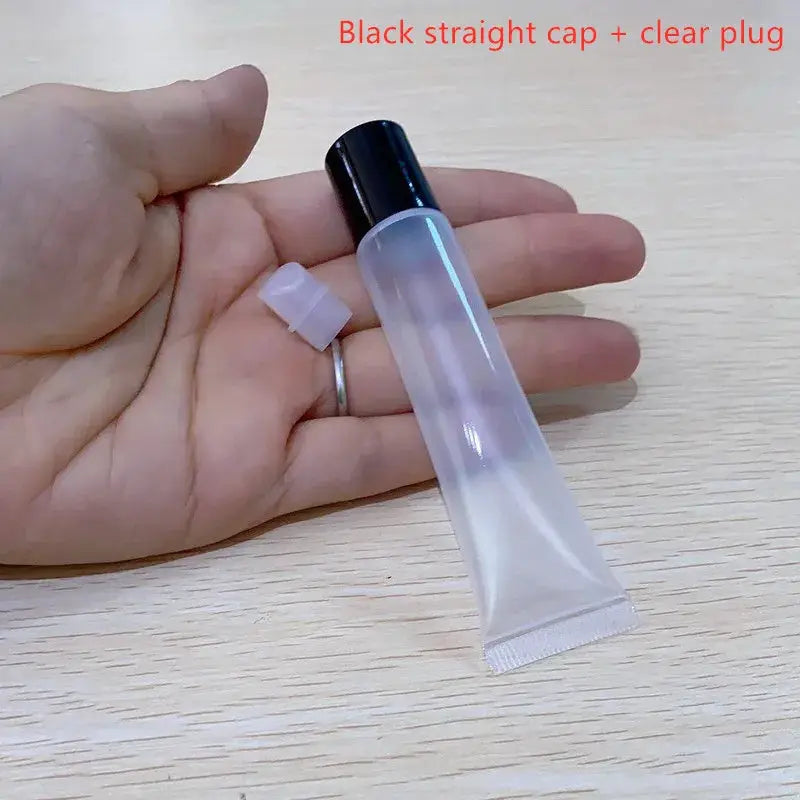 Lipstick tube with clear body and black cap; empty cosmetic container for lip gloss or lip balm