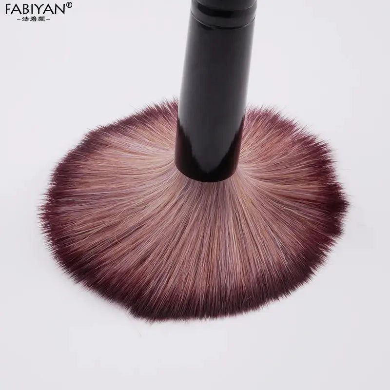 Makeup brush by FABIYAN with black handle and pink-tinted fluffy bristles
