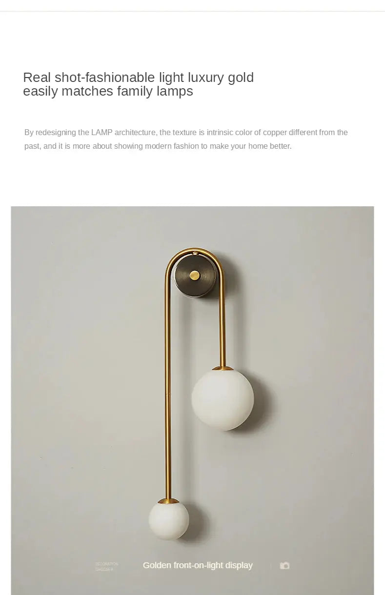 Modern wall lamp with gold finish and two white glass ball shades