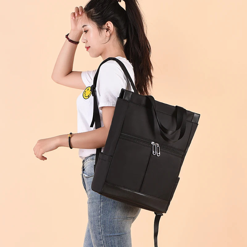 Women’s black waterproof Oxford backpack with a large main compartment and front zip pockets for school or travel.
