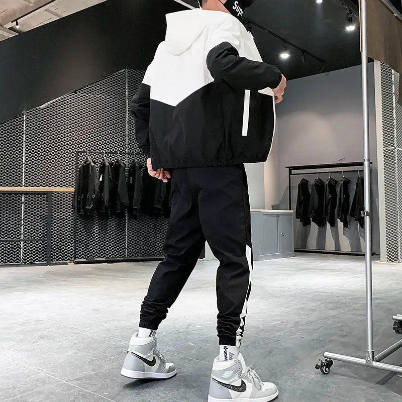 Men's 2-piece tracksuit in black and white with hooded jacket and jogger pants, paired with Nike sneakers