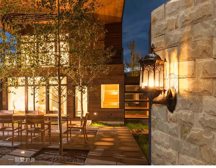 Retro outdoor waterproof antirust E27 wall lamp, black metal garden sconce illuminating a stone villa courtyard.