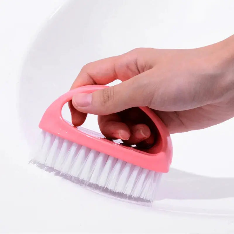 Pink egg-shaped cleaning brush with white bristles, handheld.