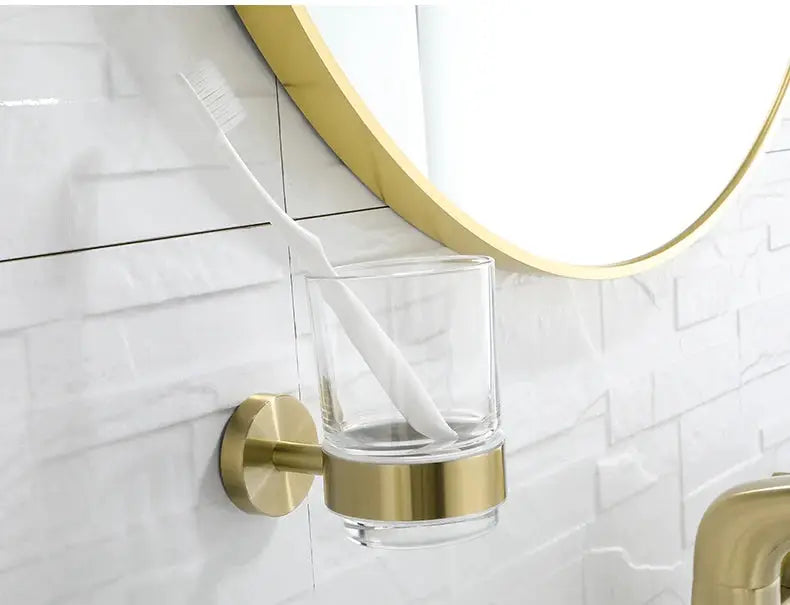 Brushed gold wall-mount toothbrush holder with clear glass cup