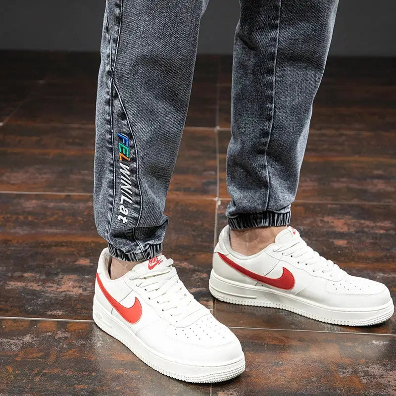 Simples Market men's cargo denim jogger jeans in dark wash with elastic cuffs and side logo; white Nike sneakers.