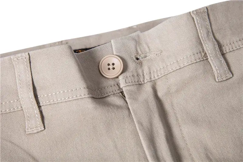 Men's khaki cotton casual trousers with belt loops and a beige button, slim fit.