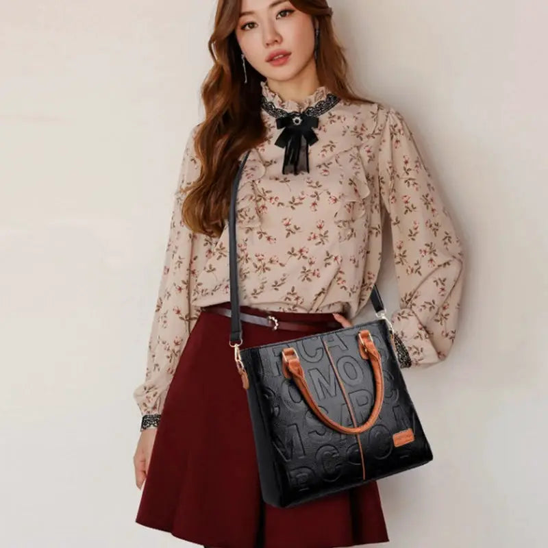 PU leather crossbody bag from Simples Market, black with tan handles, embossed pattern, large capacity.
