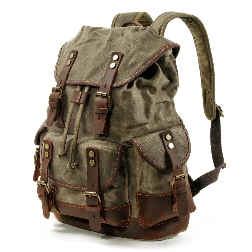 Vintage khaki canvas backpack with brown leather straps and brass buckles.