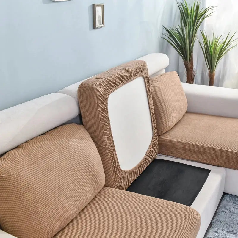 Sofa seat cushion slipcovers in tan stretch fabric; removable and washable