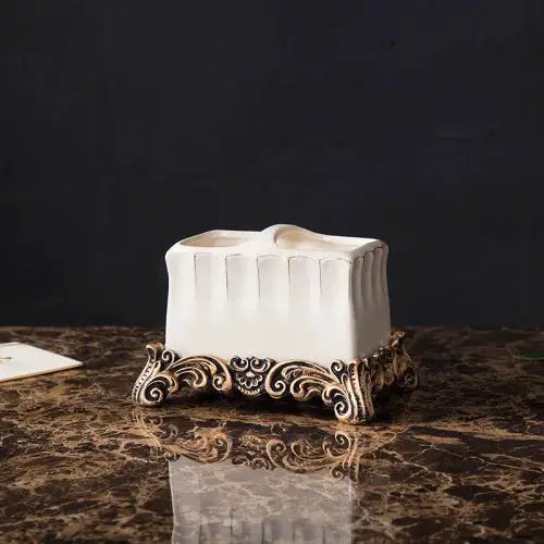 White ceramic tissue box holder with ornate gold-toned base, European bathroom decor.