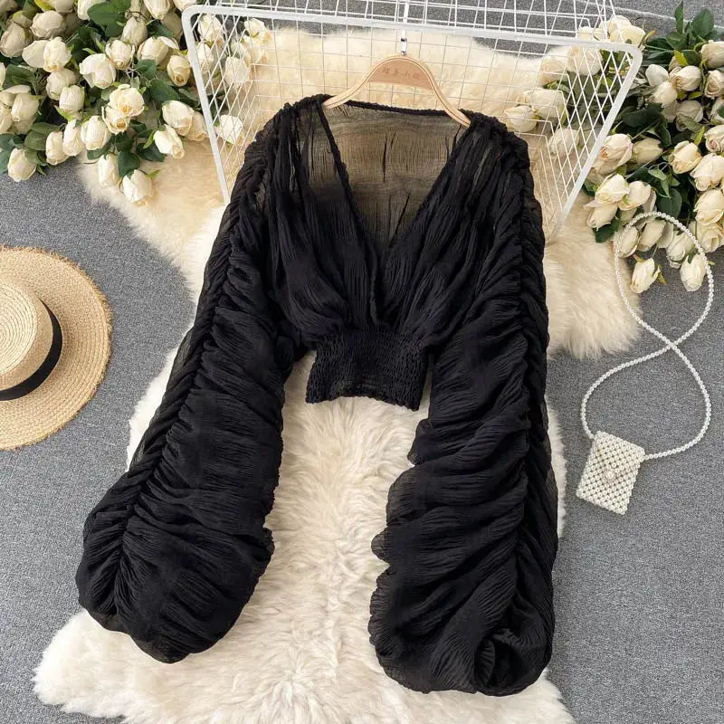 Black draped chiffon blouse with V-neck, puff long sleeves, cropped smocked waist for women.