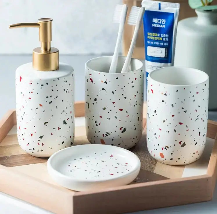 Simples Market 4-piece terrazzo ceramic bathroom set with gold soap dispenser, toothbrush cup, tumbler, and soap dish.