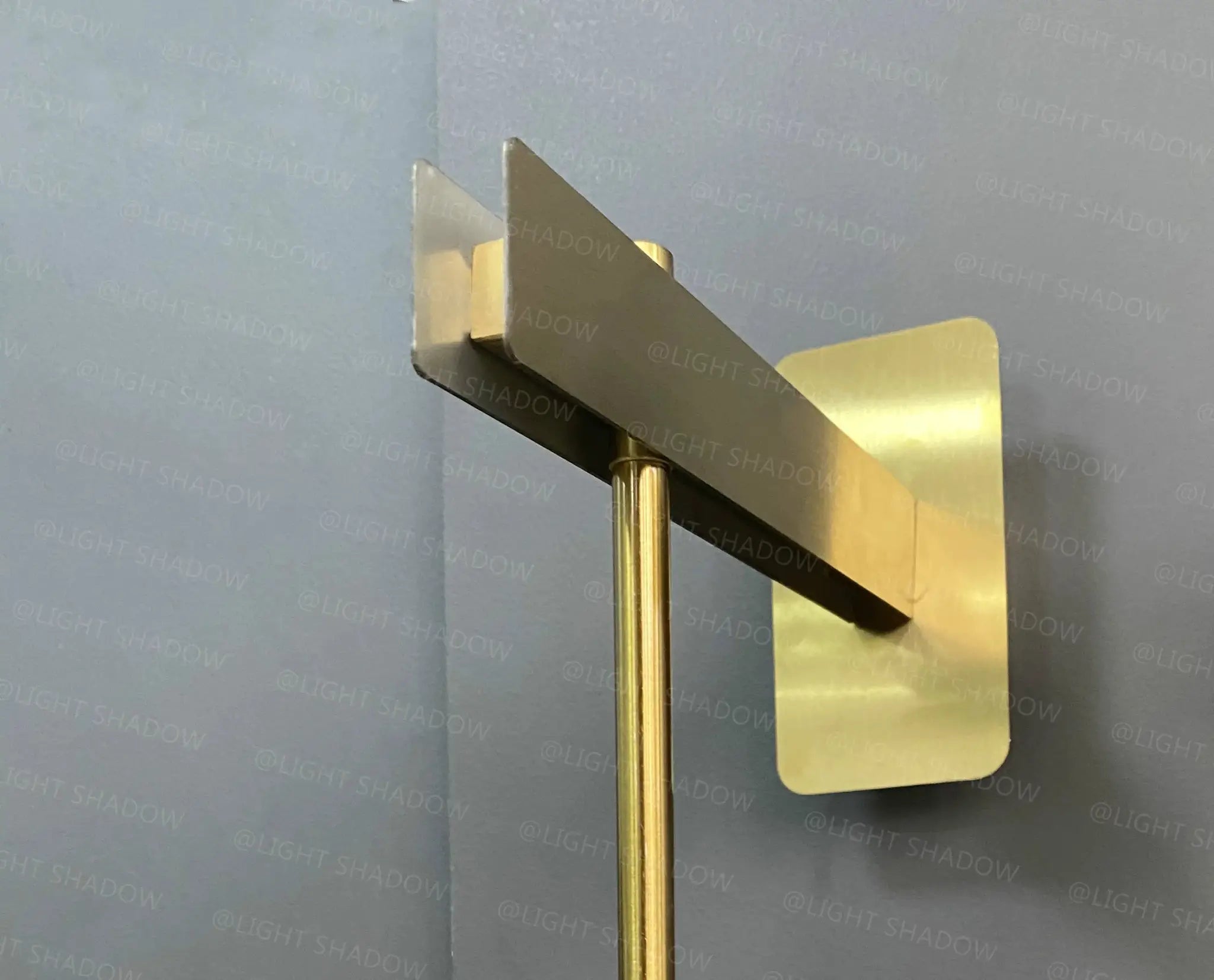 Modern glass wall light sconce; brass finish with geometric backplate and vertical stem
