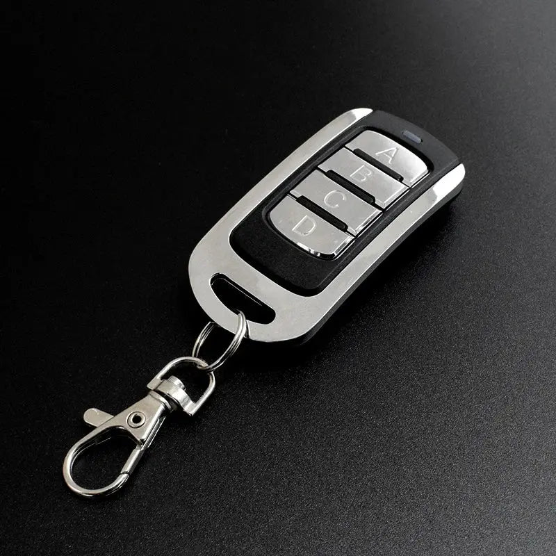 4-in-1 garage remote key fob by Simples Market, silver and black with four labeled buttons A B C D.