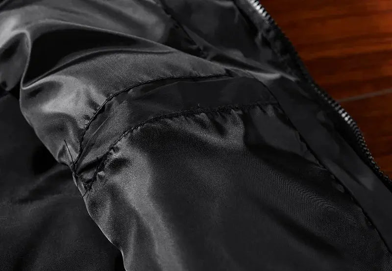 Men's black nylon vest jacket close-up showing shiny fabric, armhole seam, and visible zipper for casual spring wear