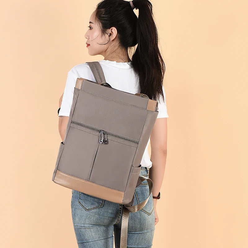 Simples Market women's backpack, gray waterproof Oxford fabric with tan base and front zip pockets.