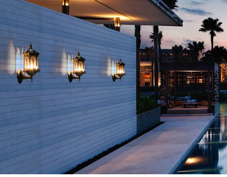 Retro outdoor E27 wall lamp sconce, 3-pack with brass finish illuminating a white poolside wall