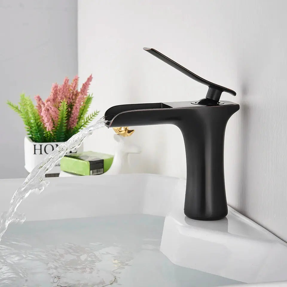 Basin faucet, black matte finish, single-handle with waterfall spout over sink.