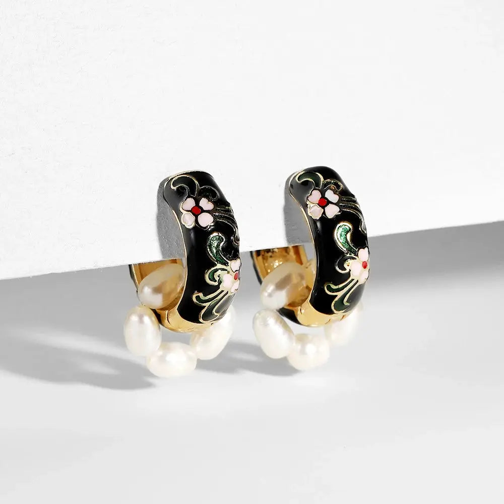 Pair of black enamel flower huggie hoop earrings with gold-tone trim and pearl dangles