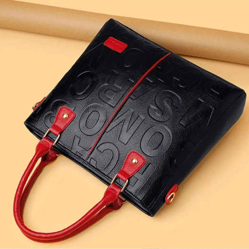 PU leather crossbody bag in black with red handles and red accent trim, gold hardware
