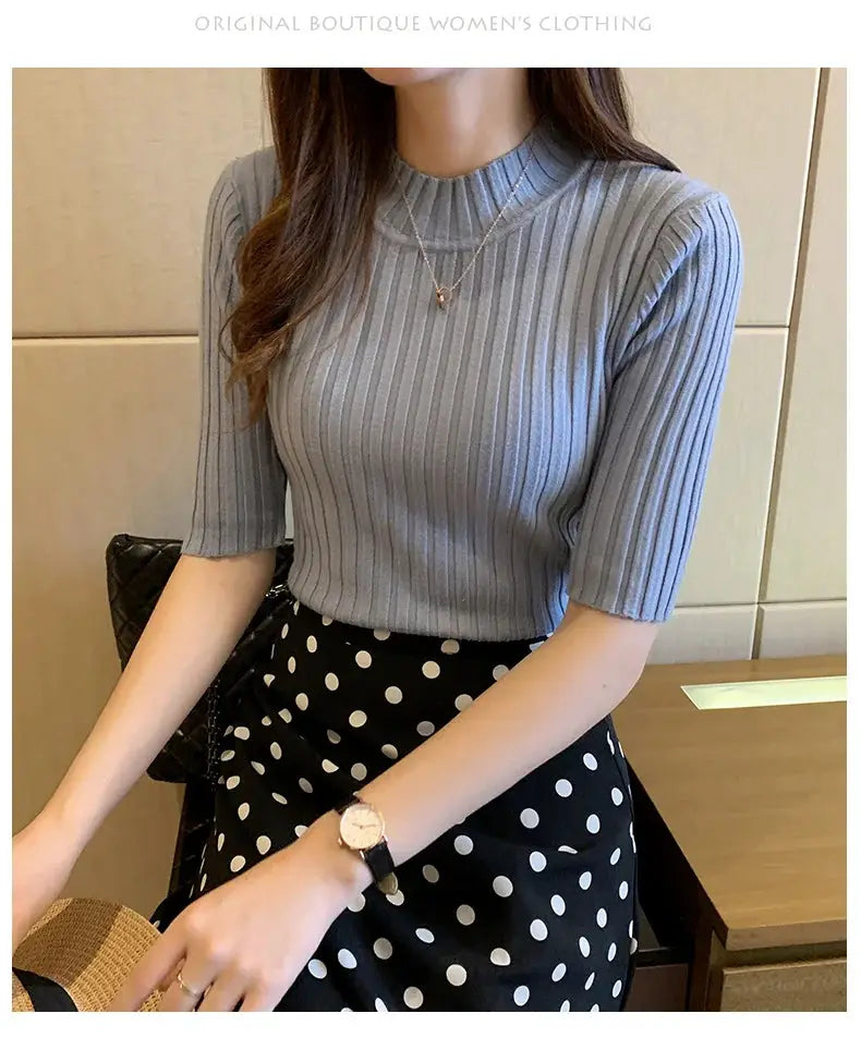 Light blue ribbed knit short-sleeve blouse worn with a black polka-dot skirt