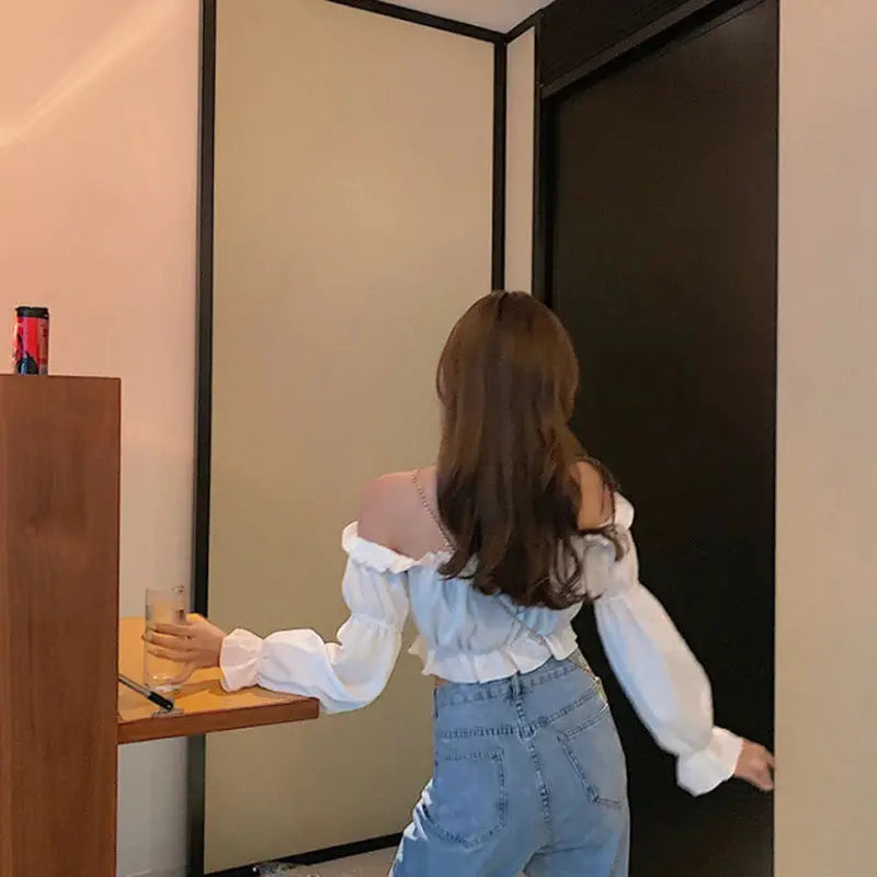 Women off-shoulder white puff-sleeve blouse, cropped top with ruffles, worn with jeans