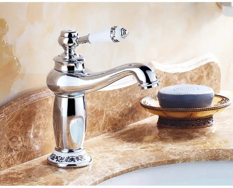 Bathroom faucet with chrome finish and white ceramic handle on a marble countertop