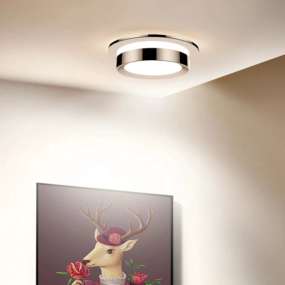 Chrome round recessed LED ceiling downlight with white acrylic diffuser.