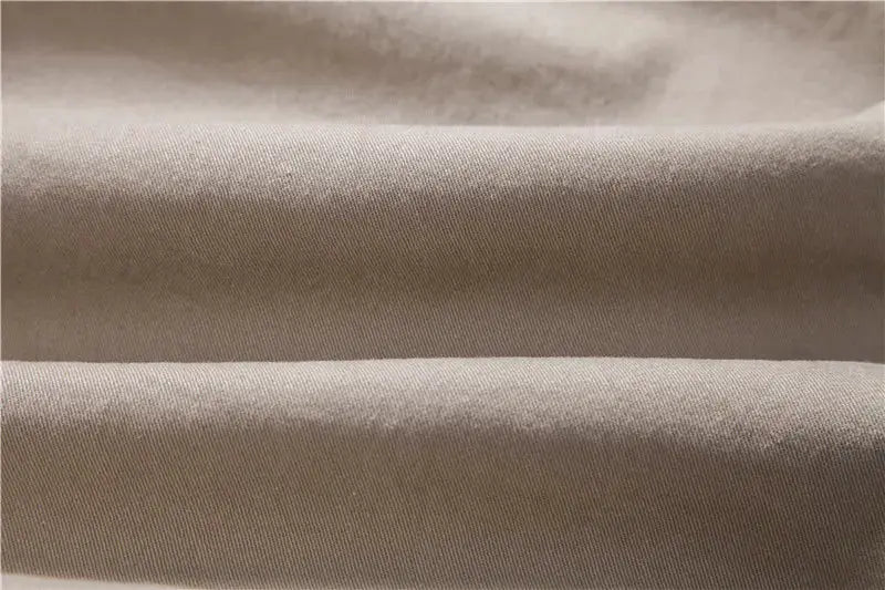 Men's cotton trousers fabric in solid beige; close-up textile texture