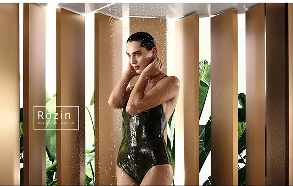 Rozin brand promotional image of a woman in a black swimsuit under a shower with water spray amid brown panels.