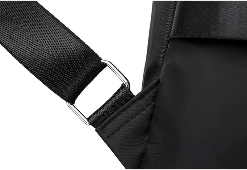 Women's black backpack strap close-up with adjustable webbing and metal buckle