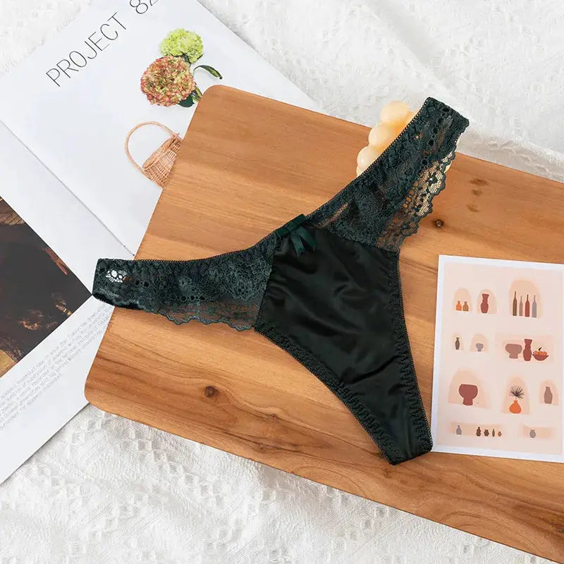 Black lace thong underwear with satin front panel and scalloped lace waistband.