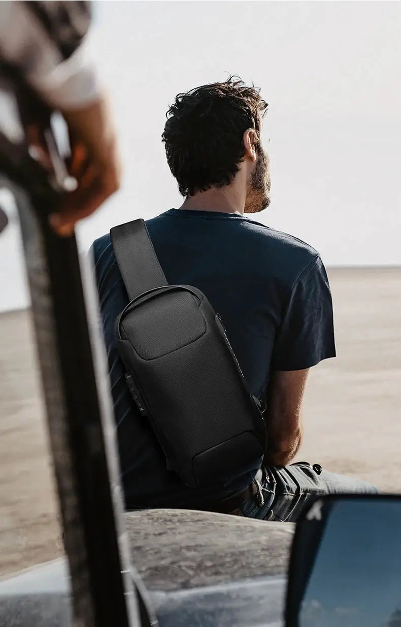BANGE black anti-theft chest crossbody bag with gray strap worn by man outdoors