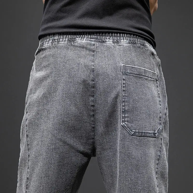 Men's grey denim jogger jeans with elastic waistband and back pocket